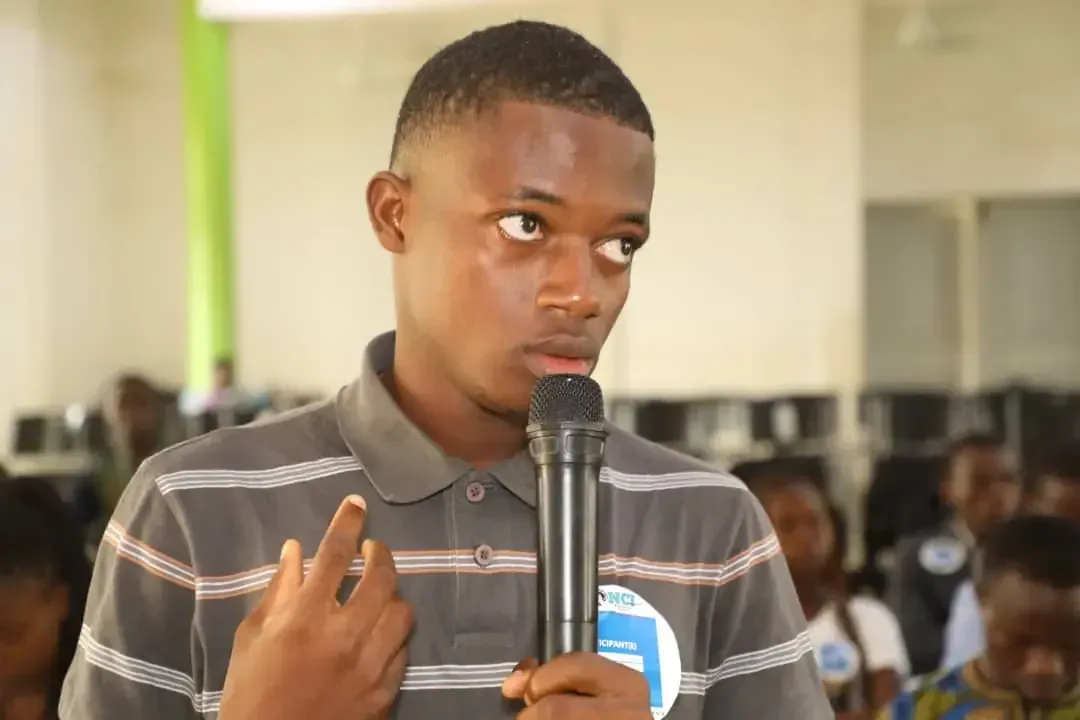 A young participant speaks into the microphone.