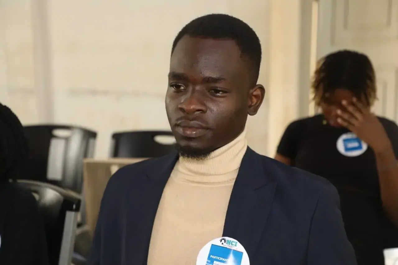 A participant in a blazer follows the discussion.