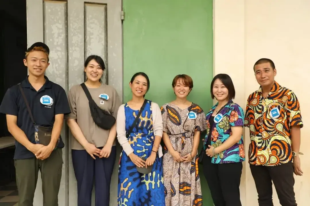 A group of international volunteers in colourful outfits.