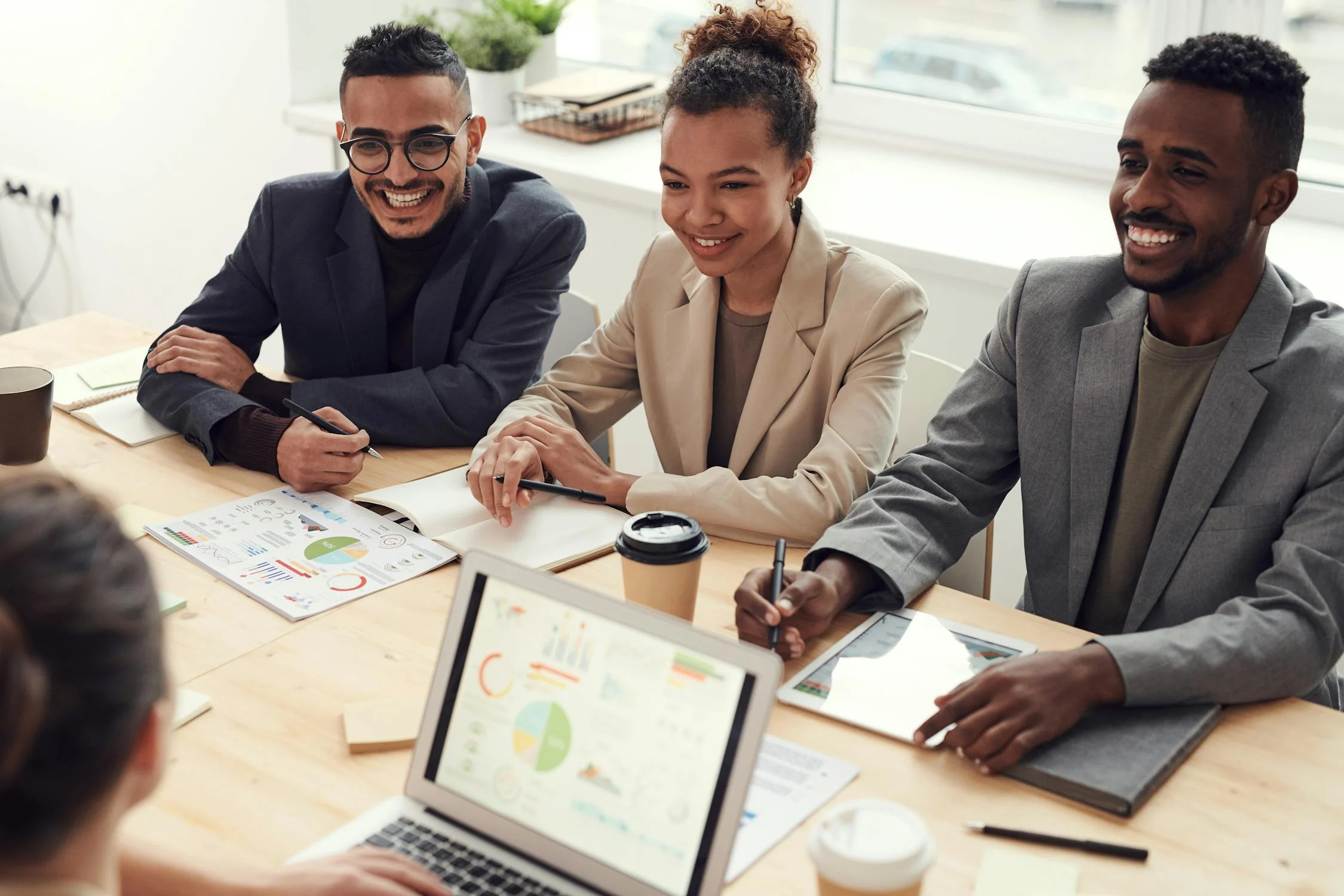 Équipe multiculturelle en discussion animée et collaborative autour d'une table.